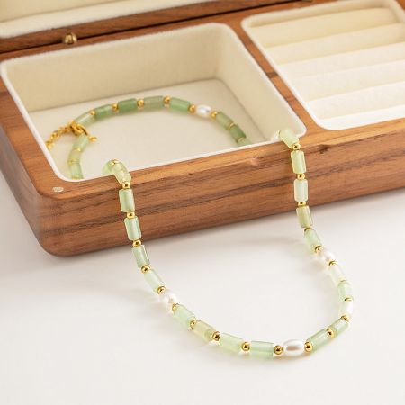 A matching bracelet with jade-like beads, pearls, and gold spacers, part of the boho collection.