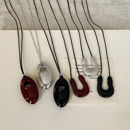 A collection of minimalist cord necklaces, including U-shape and oval pendant designs, available for wholesale.