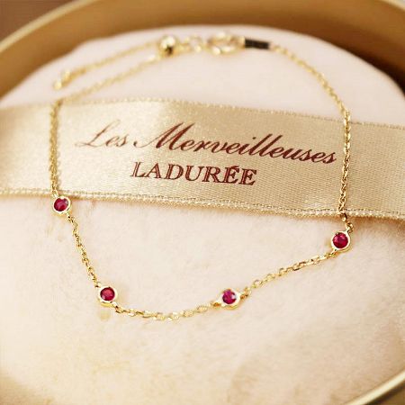 Detailed view of the gold-tone chain and clasp of the sterling silver red gemstone bracelet.