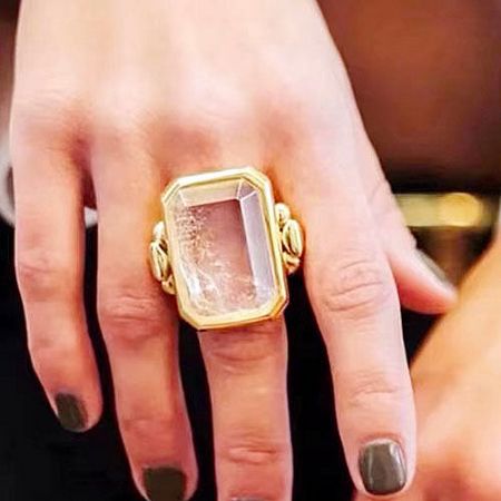 Detailed view of an ornate brass ring with a large clear gemstone from the set.