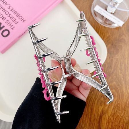 Wholesale Pink Letter Metal Hair Claw Clips (Set of 5) - A large silver butterfly-shaped metal hair claw clip with pink accents, held in hand to show its size and detail.