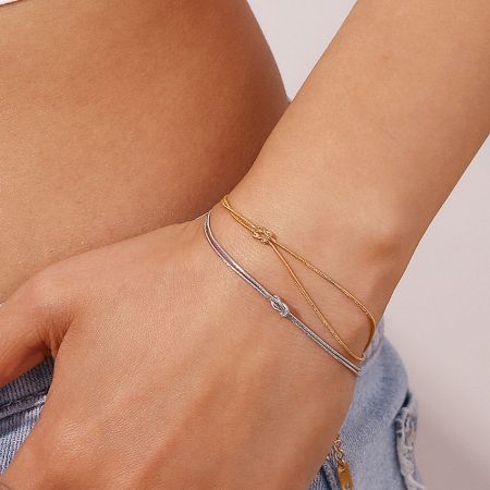 Close-up of the double-layered gold snake chain knot bracelet on a wrist, showcasing its elegant design.
