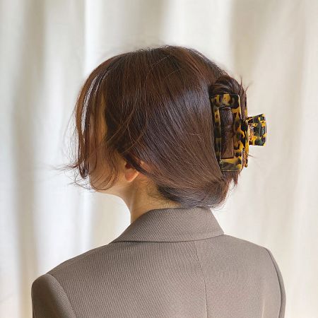 A model showcasing a stylish low bun held in place with a leopard-print claw clip.