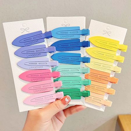3pcs/pack No-Crease Seamless Side Hair Clips (5 Sets) - A hand holding several packs of colorful no-crease seamless side hair clips, showcasing the variety of available color sets.