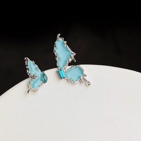 A pair of light blue butterfly earrings with a silver finish, showcasing their unique design.