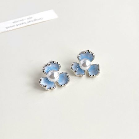 Angled shot of the gradient blue enamel flower earrings, showing their delicate shape.