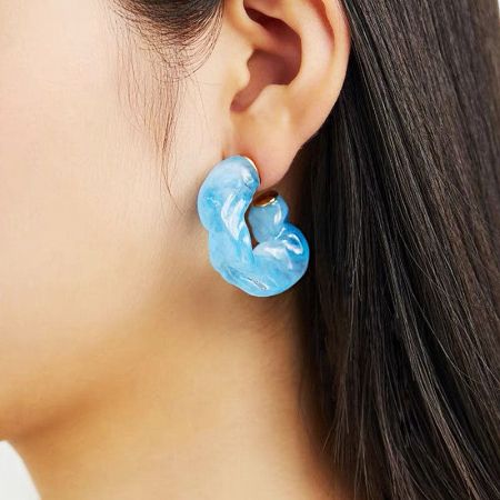 Side profile of a model wearing the light blue C-shape stud earring.