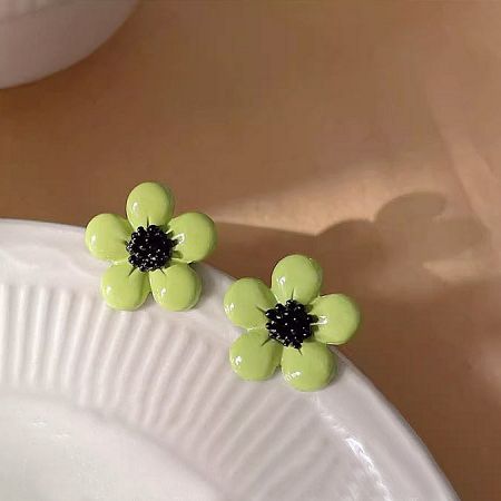 Another angle of the light green daisy earrings, highlighting the enamel work.