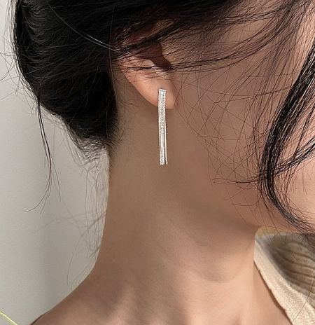 A model wearing the long 925 sterling silver tassel earring to show its scale and drape.