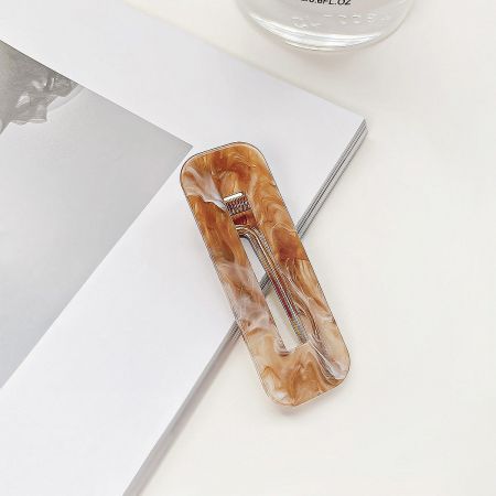 Detailed product photo of a brown marbled acrylic hair clip.