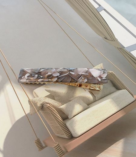 Close-up of a stylish marbled acetate resin hair clip.