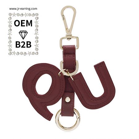 Maroon PU leather keychain with 'QU' initials, ideal for OEM/B2B branding.