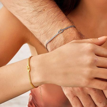 Minimalistic Tie the Knot Double Layered Couple Gold Thin Snake Chain Knot Bracelet Set of 5 - A couple wearing matching minimalistic tie-the-knot bracelets, one in gold and one in silver, symbolizing their connection.