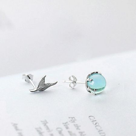 Close-up of the asymmetrical mermaid tail and moonstone stud earrings in sterling silver.