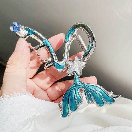 Detailed view of the mermaid hair clip with blue and white enamel and a starfish accent.