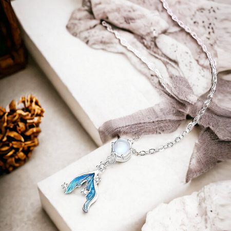 Side view of the sterling silver mermaid tail necklace with a pale moonstone.