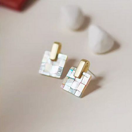 Detailed view of a multi-color mosaic earring with a prominent gold accent.