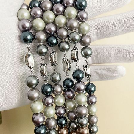 A collection of five Morandi color glass pearl necklaces showing their subtle color variations.