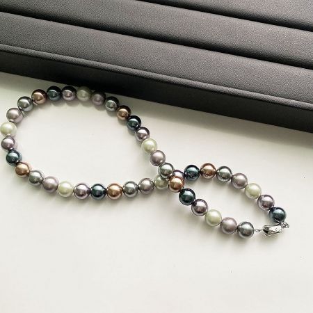 Close-up of the multicolored pearl necklace highlighting the secure silver-tone clasp.