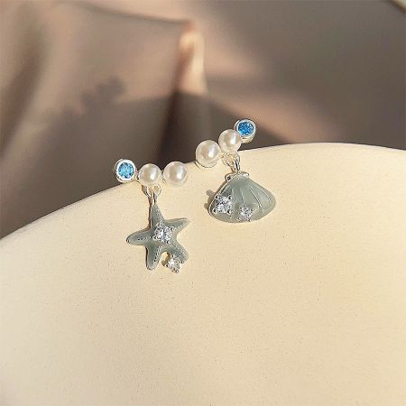Detailed view of the nautical-themed starfish and scallop shell earrings with blue gemstones.