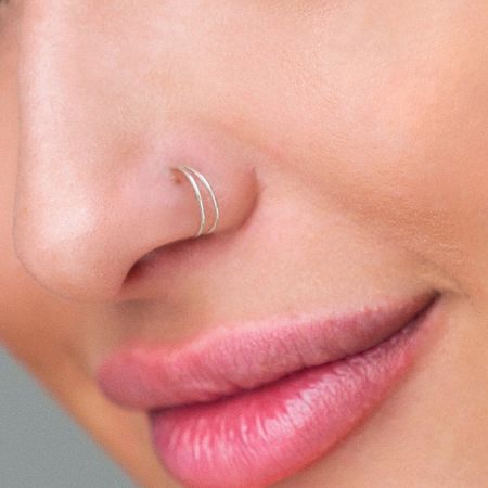 Side profile showing the stylish look of the double gold hoop fake nose piercing.
