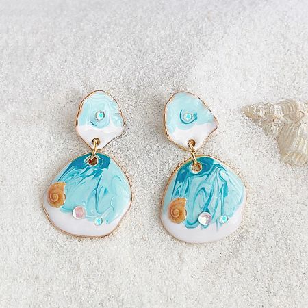Elegant ocean-themed earrings with a marbled blue design, accented with golden seashells and sparkling iridescent gems.