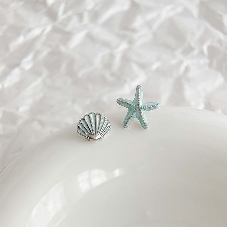 Detailed view of the ocean-themed brass earrings with turquoise and silver finish.