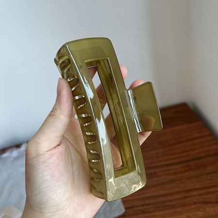 A large olive-green rectangle hair clip made of shiny acetate.