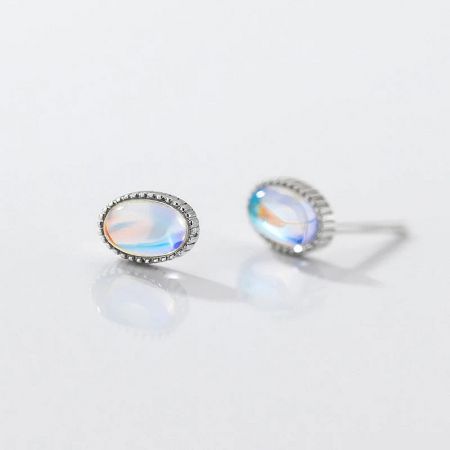 Detailed product shot of an oval moonstone earring, highlighting the stone's colorful play-of-light.