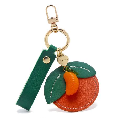 Detailed view of a tangerine-style PU leather keychain with delicate stitching and a small fruit charm.