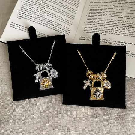 Wholesale gold and silver plated brass necklaces with decorative padlock charms and floral details.