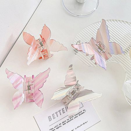 Four pastel-colored butterfly hair clips in shades of pink, blue, green, and yellow.