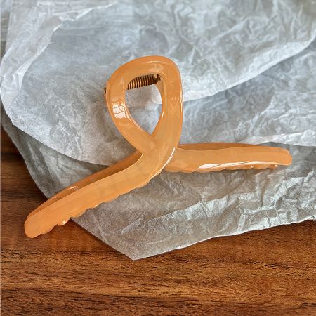 Peach colored acetate hair jaw clip with French design.
