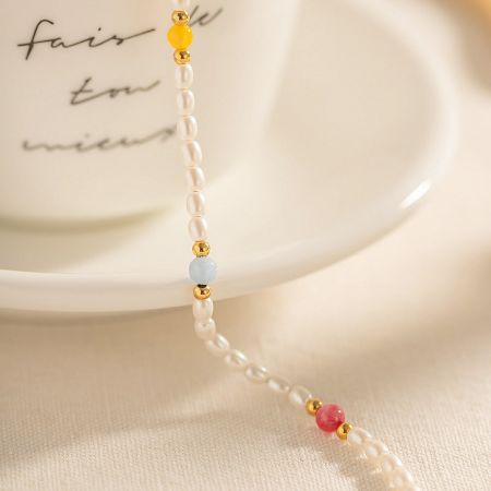 Close-up product shot of the stainless steel anklet with pearls and multi-colored beads.