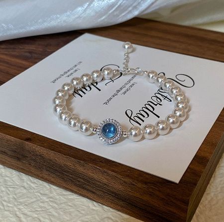925 Sterling Silver Pearl Blue Bracelet - Elegant 925 sterling silver pearl bracelet featuring a stunning central blue gemstone and sparkling cubic zirconia accents.