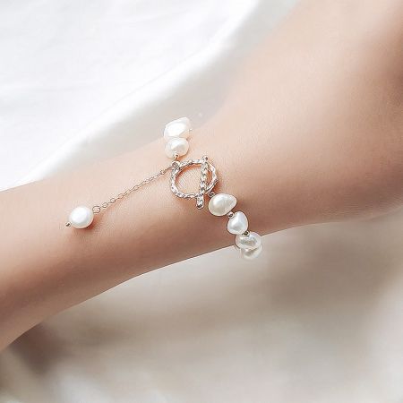 14k Gold-Plated Baroque Freshwater Pearl Chain Toggle Clasp Bracelets (Set of 5) - A model's wrist adorned with an elegant 14k gold-plated baroque freshwater pearl bracelet, featuring a secure toggle clasp. Part of a set of five.