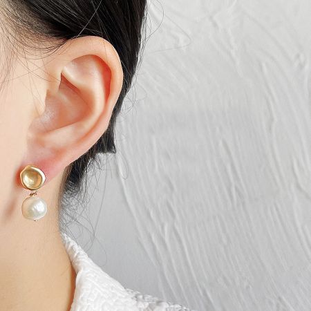 A detailed close-up of the earring, highlighting the unique irregular shape of the freshwater pearl.