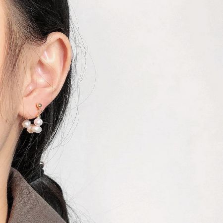 Model wearing the 14K gold plated baroque freshwater pearl stud earring to show scale and style.
