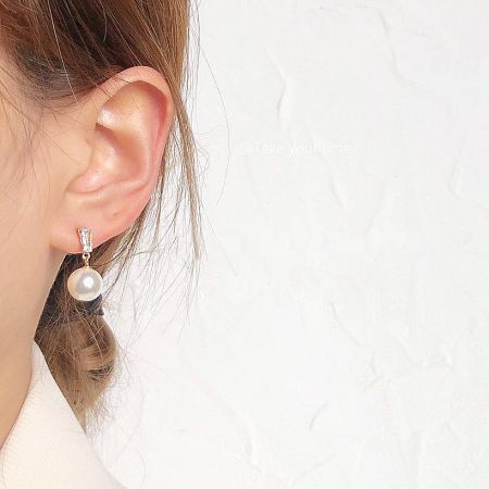 Close-up view of the simple pearl drop earring being worn, showcasing its elegant design.