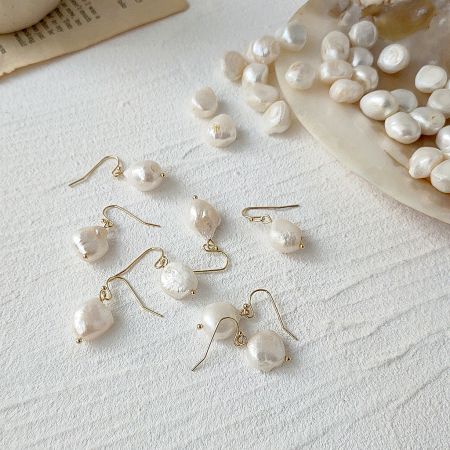 Baroque Irregular Natural Freshwater Pearl Gold Hook Drop Earrings (5 Pairs) - A collection of Baroque irregular freshwater pearl drop earrings with gold hooks, displayed alongside loose pearls on a clean white surface, showcasing the set of five pairs.