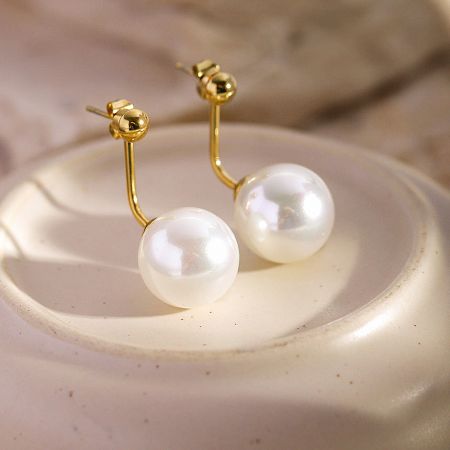 Close-up of the gold hook design on the French-style pearl earrings.