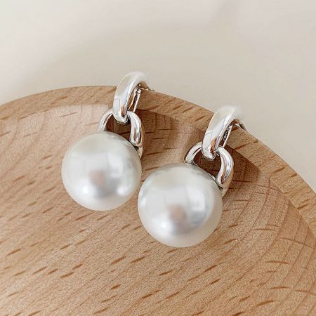 A pair of high-quality pearl drop earrings, showcasing their lustrous surface.