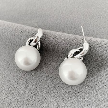 A pair of pearl earrings featuring silver hooks and delicate chain elements.