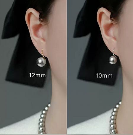 Size comparison of the 925 Sterling Silver Silver Grey Pearl Hook Earrings on a model's ear.