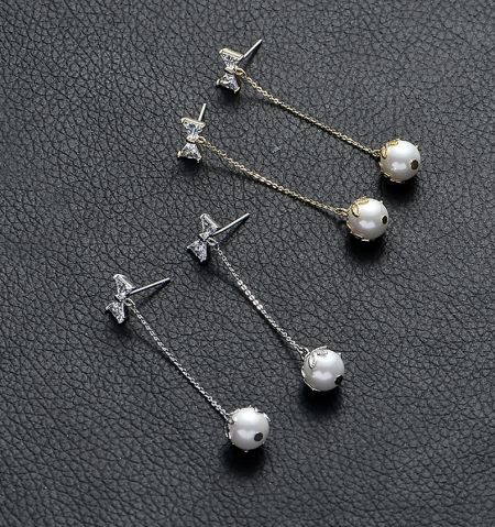 Detailed view of the pearl and cubic zirconia accents on the dangle earrings.