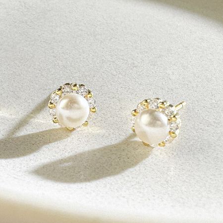 Detailed shot of the pearl earrings highlighting the surrounding clear stones.
