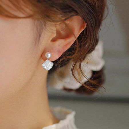 Front view of the unique fan-shaped white shell and freshwater pearl earrings.