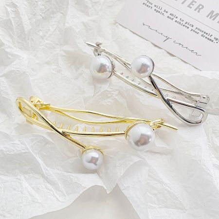 Gold and silver versions of the twisted double pearl hair clips shown side-by-side.