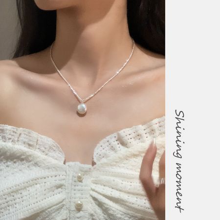 Close-up of the vintage baroque pearl necklace worn with a white top, showcasing its elegant design.