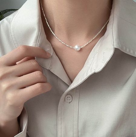 A model wearing the 925 Sterling Silver Faceted Beaded Pearl Necklace to showcase its length and style.